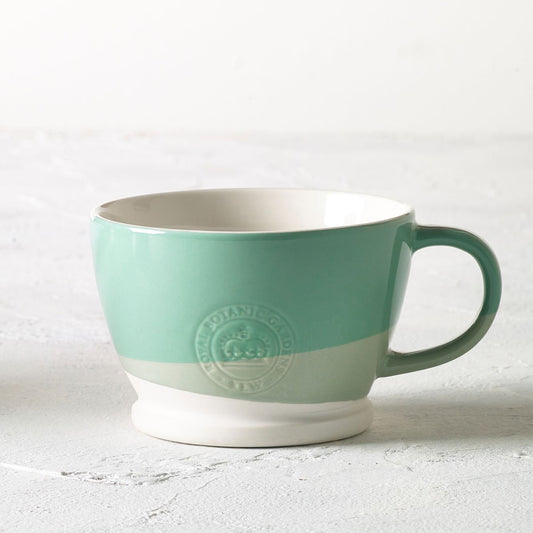 Mug with two sloping bands of turquoise green, one large band of mid green and a smaller band below that of pale green on a white background, with white interior. From Kew Gardens available from Vinegar Hill.